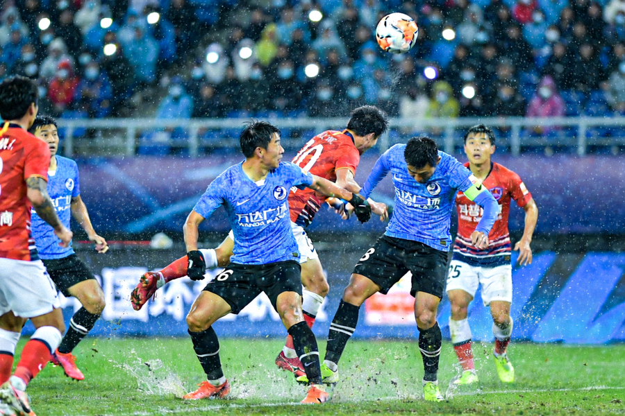 中超联赛焦点战球员在雨夜球场激烈拼抢的现场画面