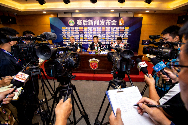 足球场边记者席与摄像机记录赛后新闻发布会